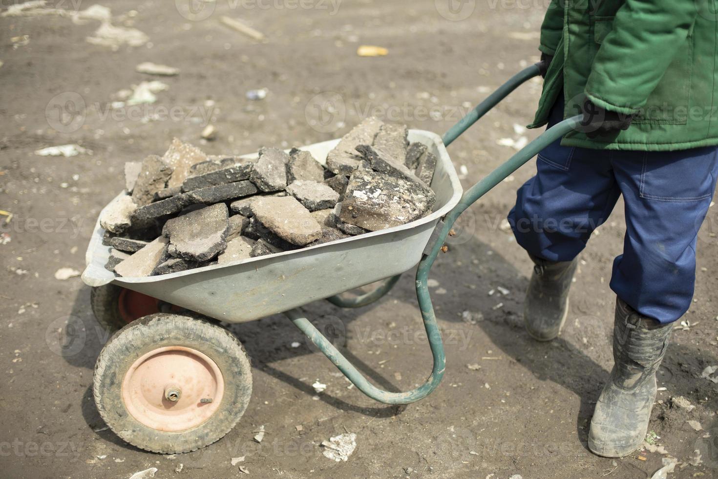 Transportation of broken stone. Worker dismantles block of stones. photo