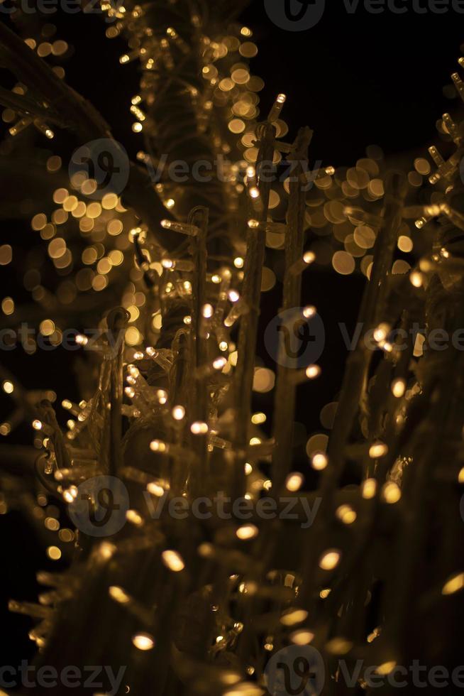 Yellow lights in dark. New Year's texture. Wood made of garlands. Lots of lights. photo