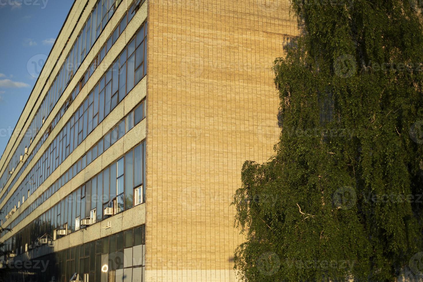 Old building of brick and glass. Long industrial building in city. photo