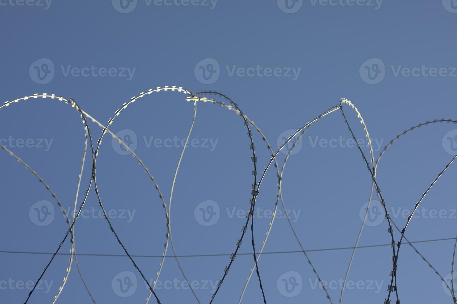 Barbed wire rings on fence. Protected area. photo