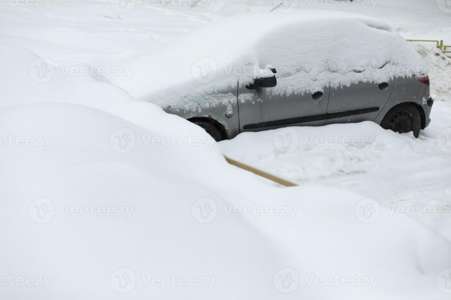 Car in winter in parking lot. Car is parked in snow. Snowdrifts in parking lot. photo