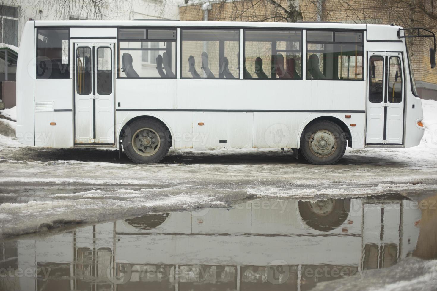 Bus and puddle. White transport. photo