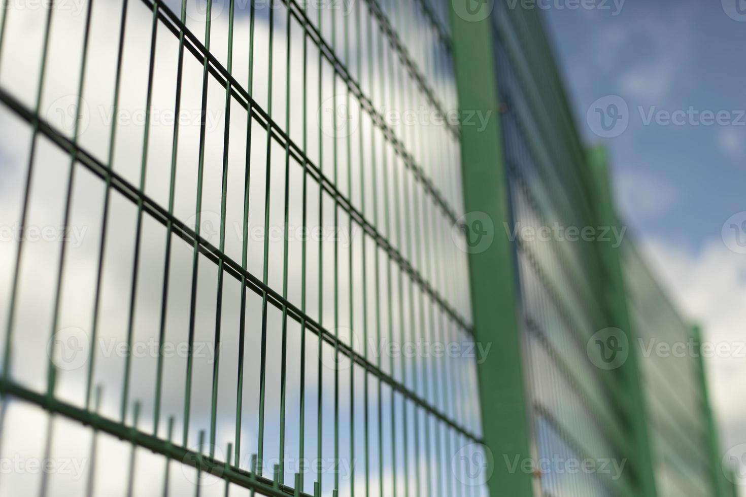 cerca verde malla de acero en campo deportivo. foto