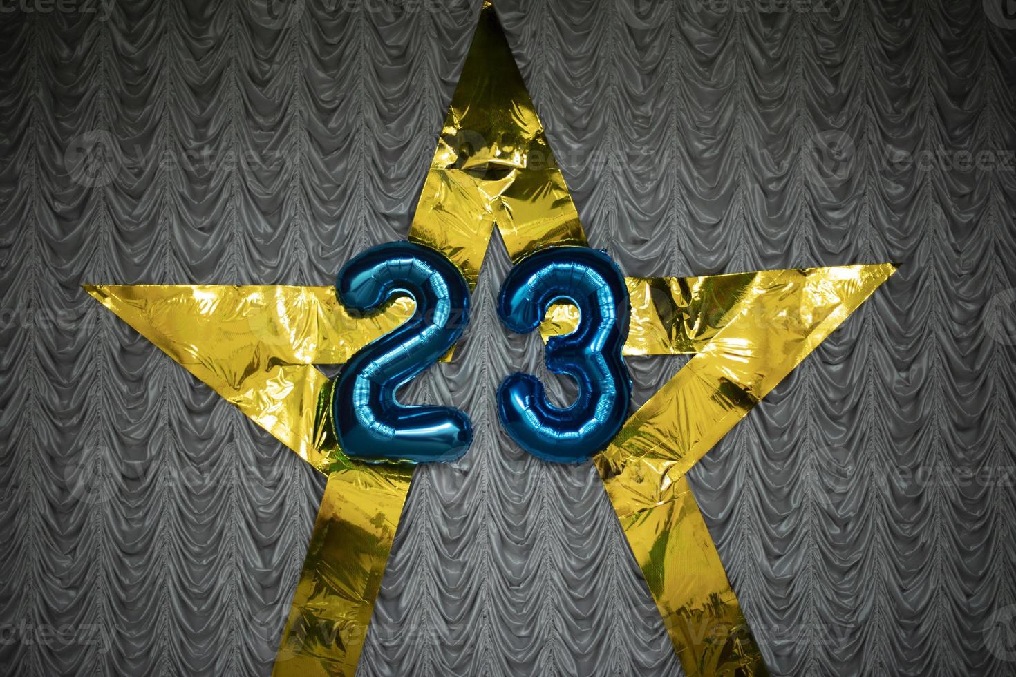 número 23 de globos. decoración con números. la estrella de oro cuelga de la tela. foto