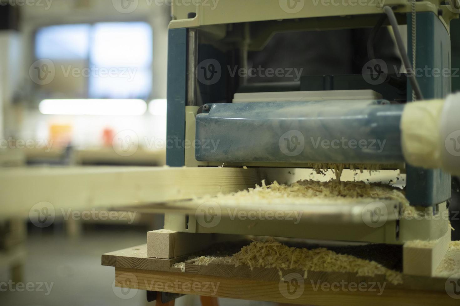 Cutting board in wood workshop. Processing of wood bar. Sawing off layer. photo