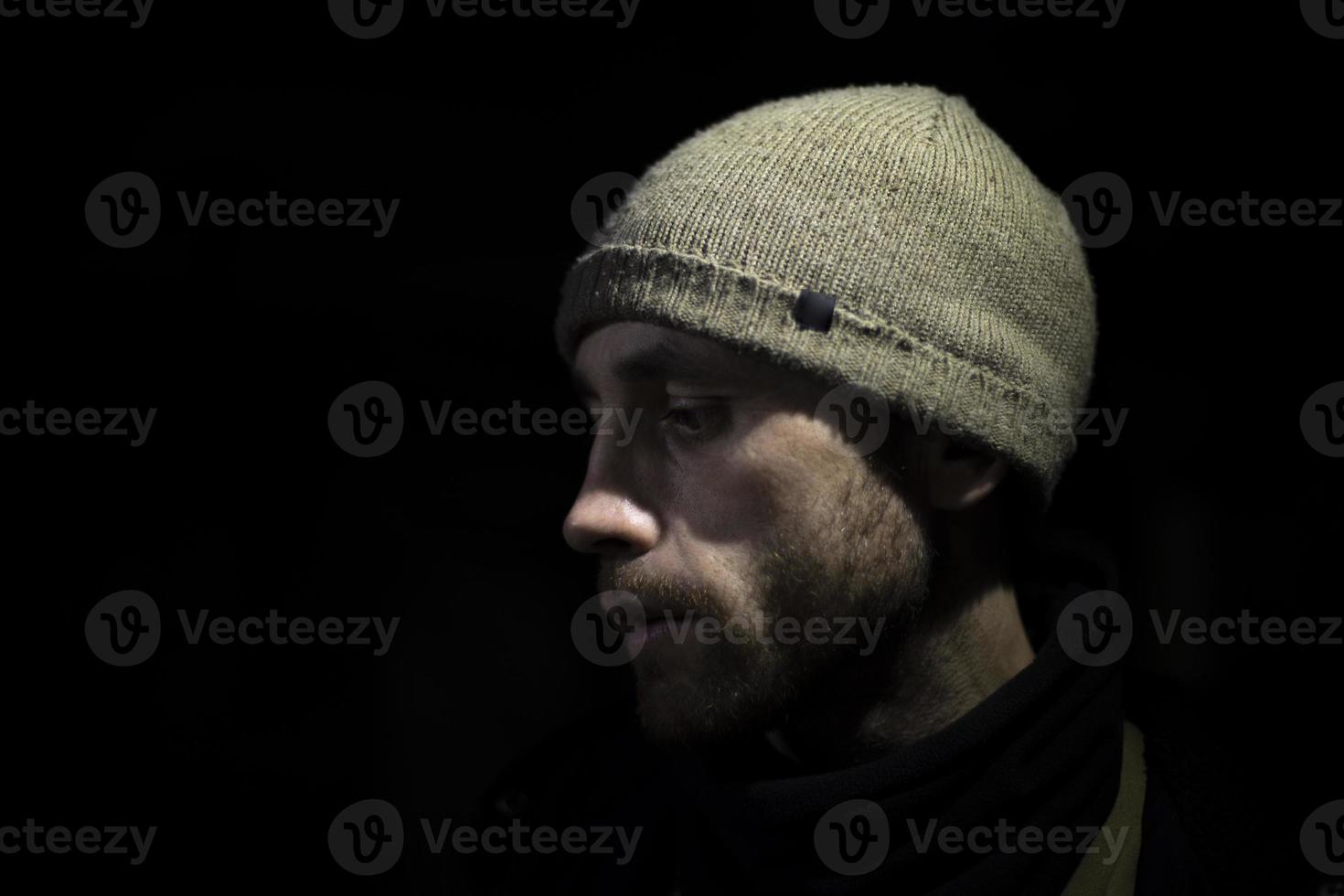 Guy in hat on black background. Man in dark. Modern hat style. photo