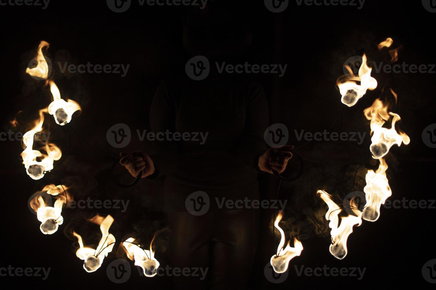 Fireshow in dark. Two steel fans with hot flames. photo