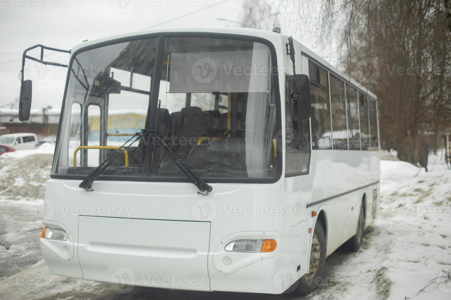 autobús blanco en el estacionamiento. transporte público en invierno. foto