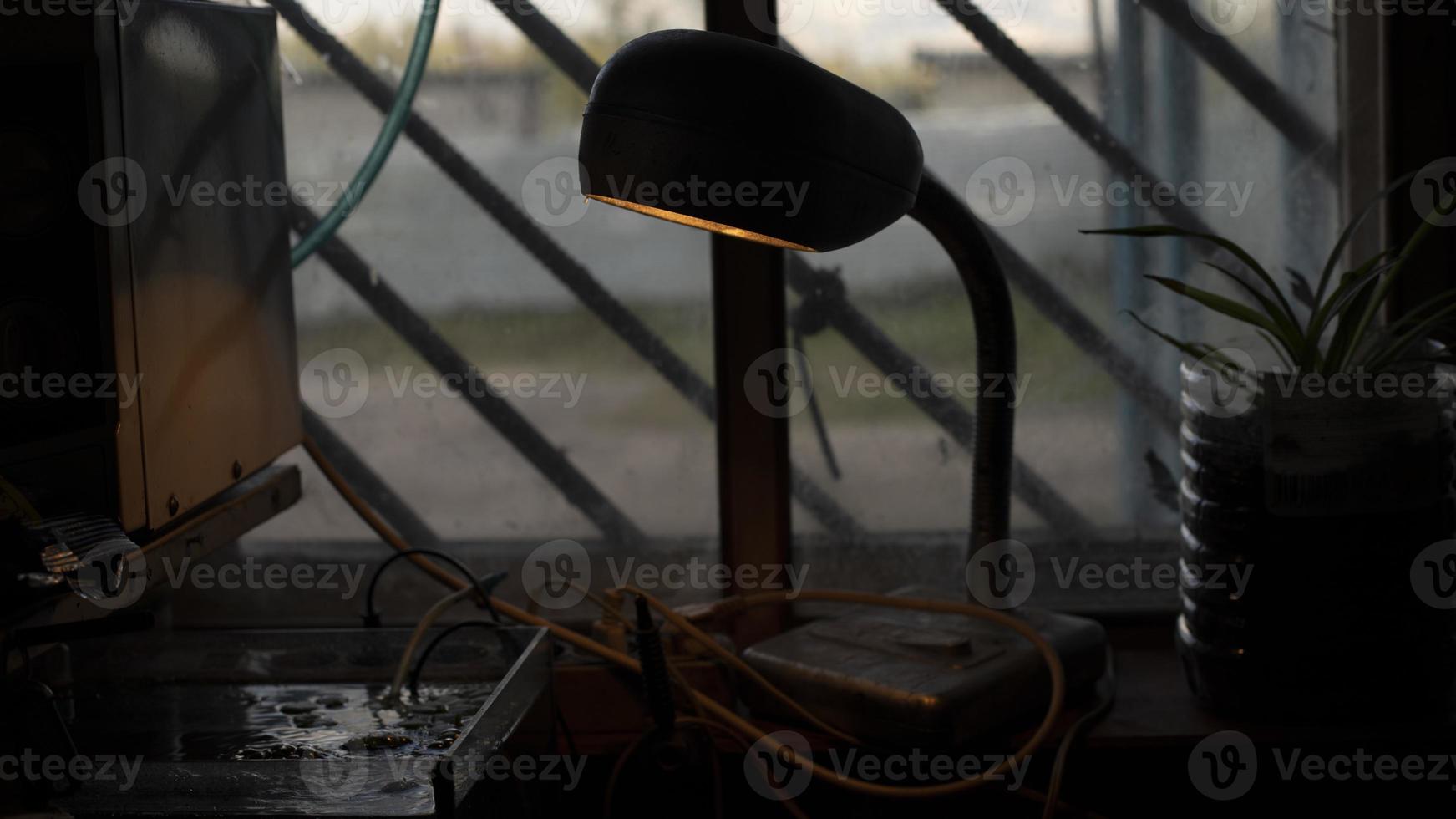 lámpara de mesa en la habitación. luz en la mesa. lámpara incandescente de tipo antiguo. foto