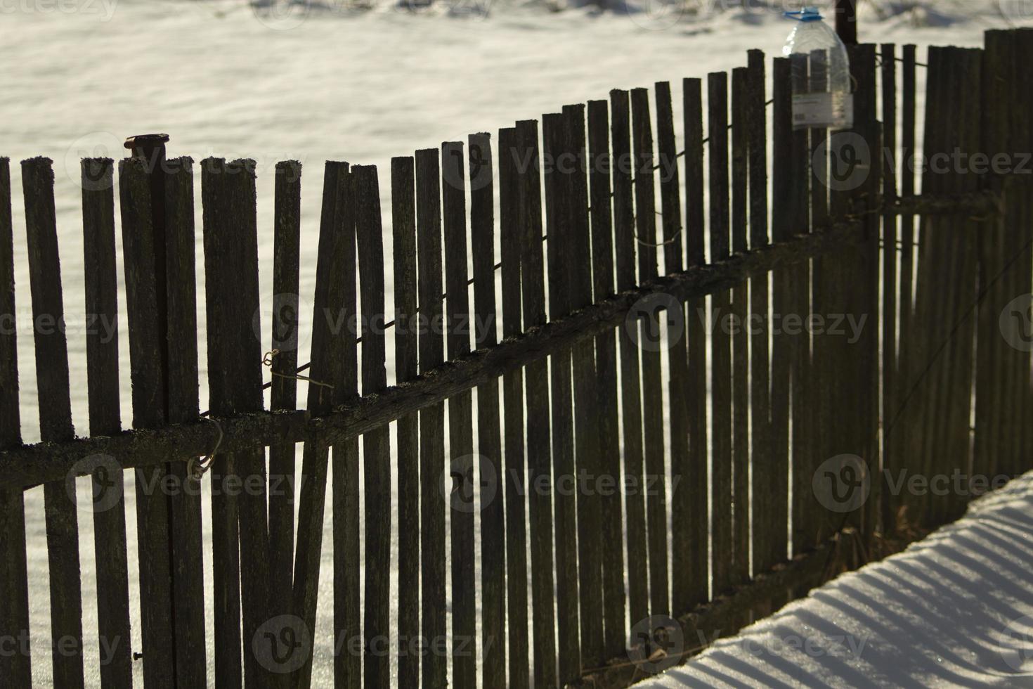 Fence made of wood in winter. Wooden fence in countryside. photo