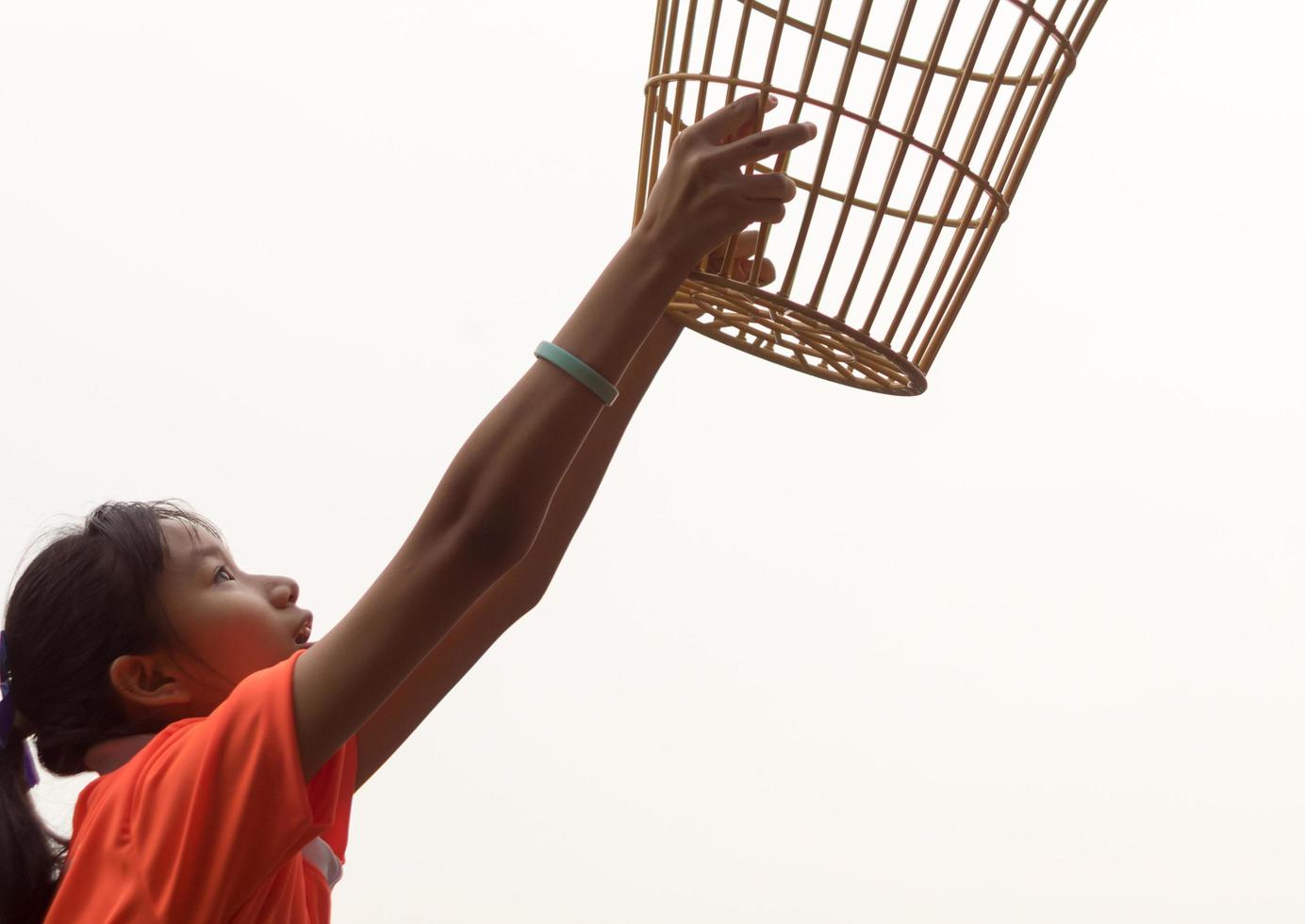 A girl in a basket holding position in a school chairball game