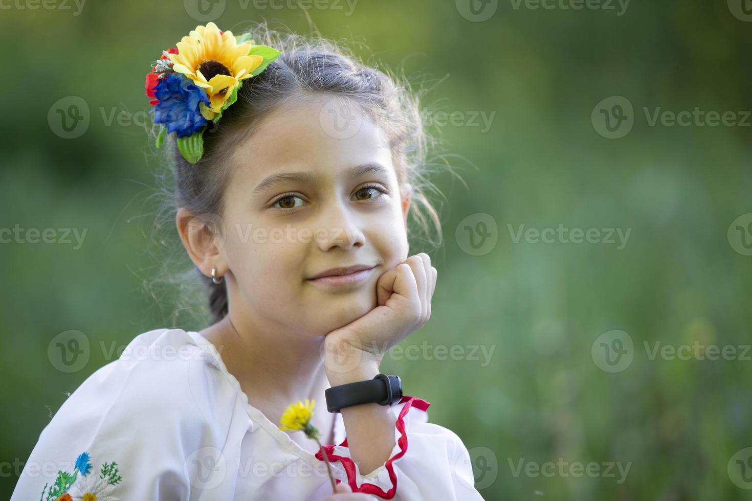 A little Ukrainian and Belarusian girl in an embroidered shirt on a summer background. photo