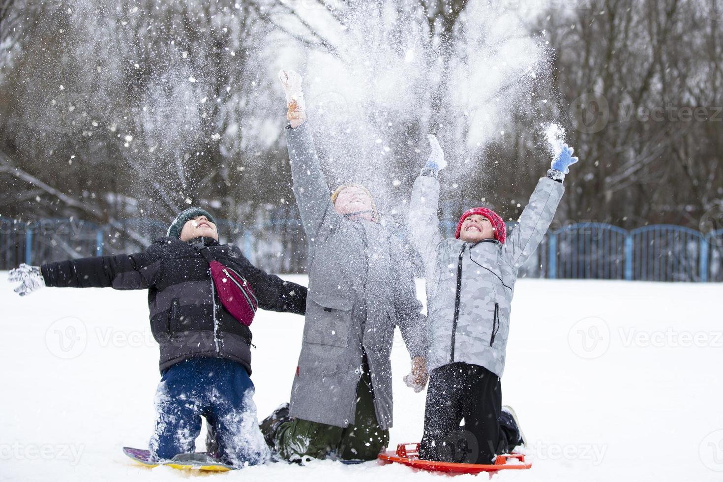 Children in winter. Three little boy friends are playing in the snow. photo
