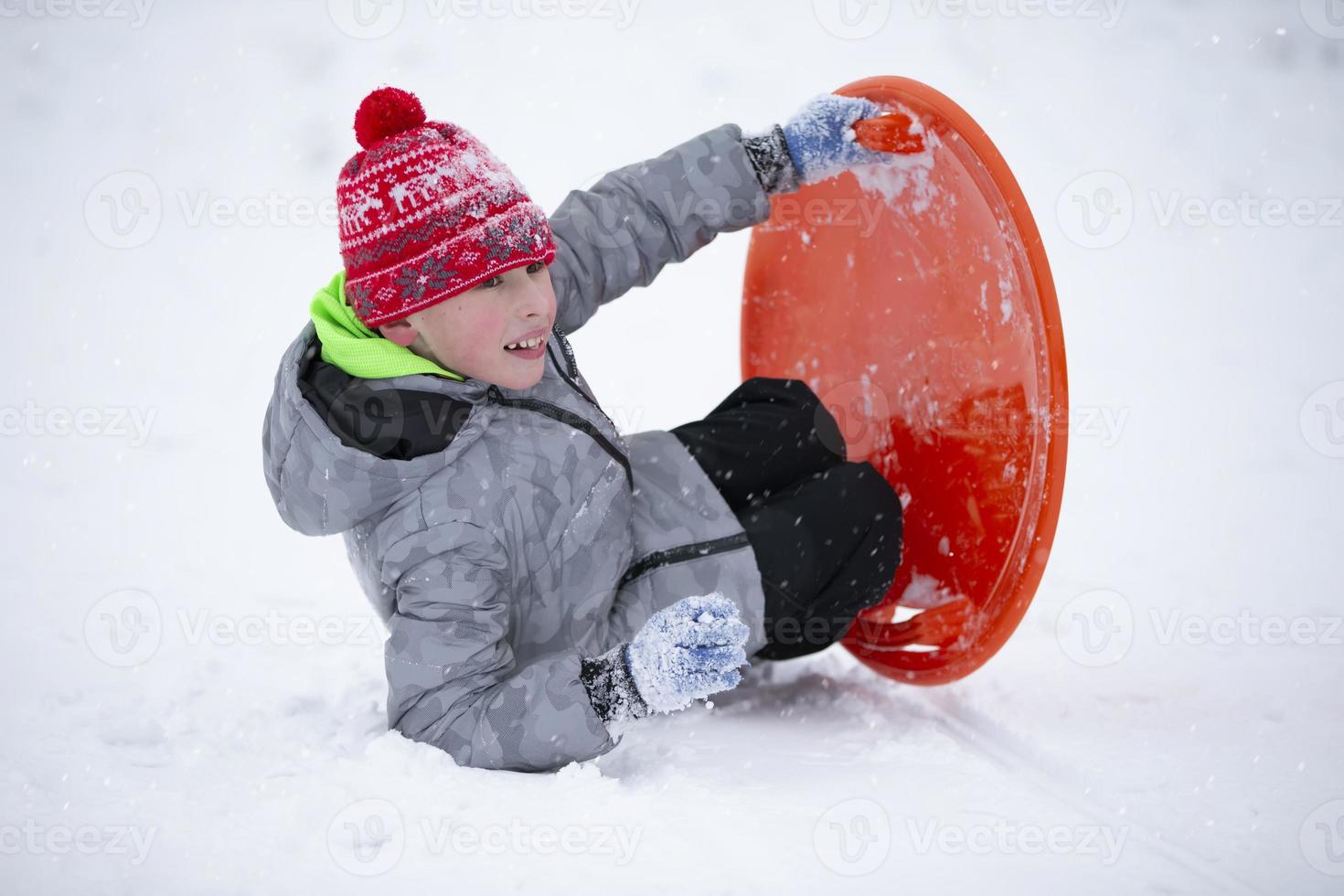 Child in winter. The boy is sledding. photo