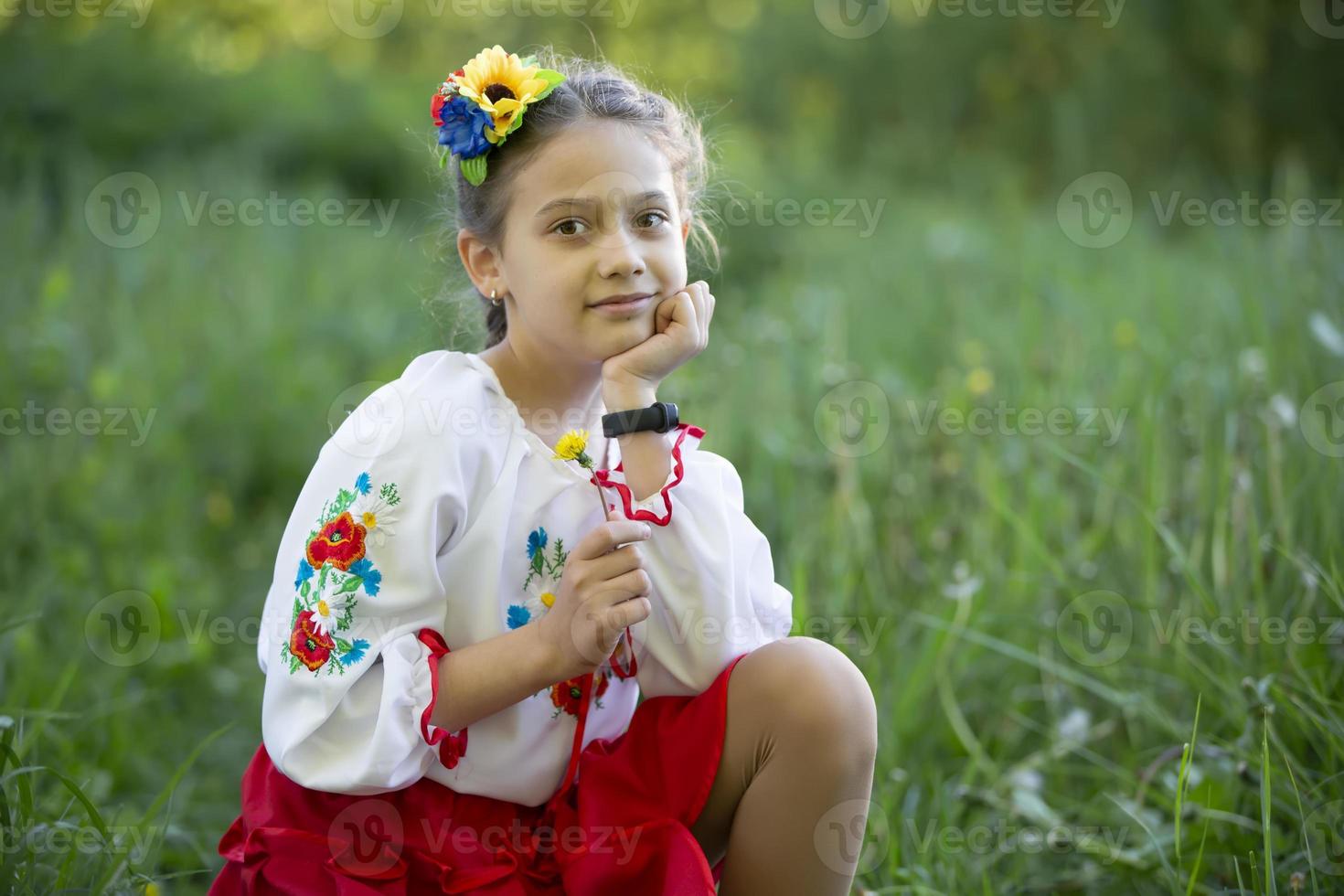 A little Ukrainian and Belarusian girl in an embroidered shirt on a summer background. photo