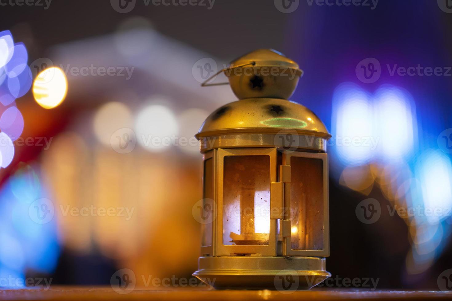 Golden vintage lantern on evening bokeh background.Yellow lantern on a bench at night. The background is blurred. Old lantern. Evening light. Bokeh photo