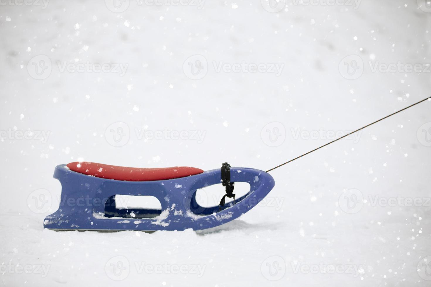 Snow sled on a snowy background.Children's sledge for a hill. photo