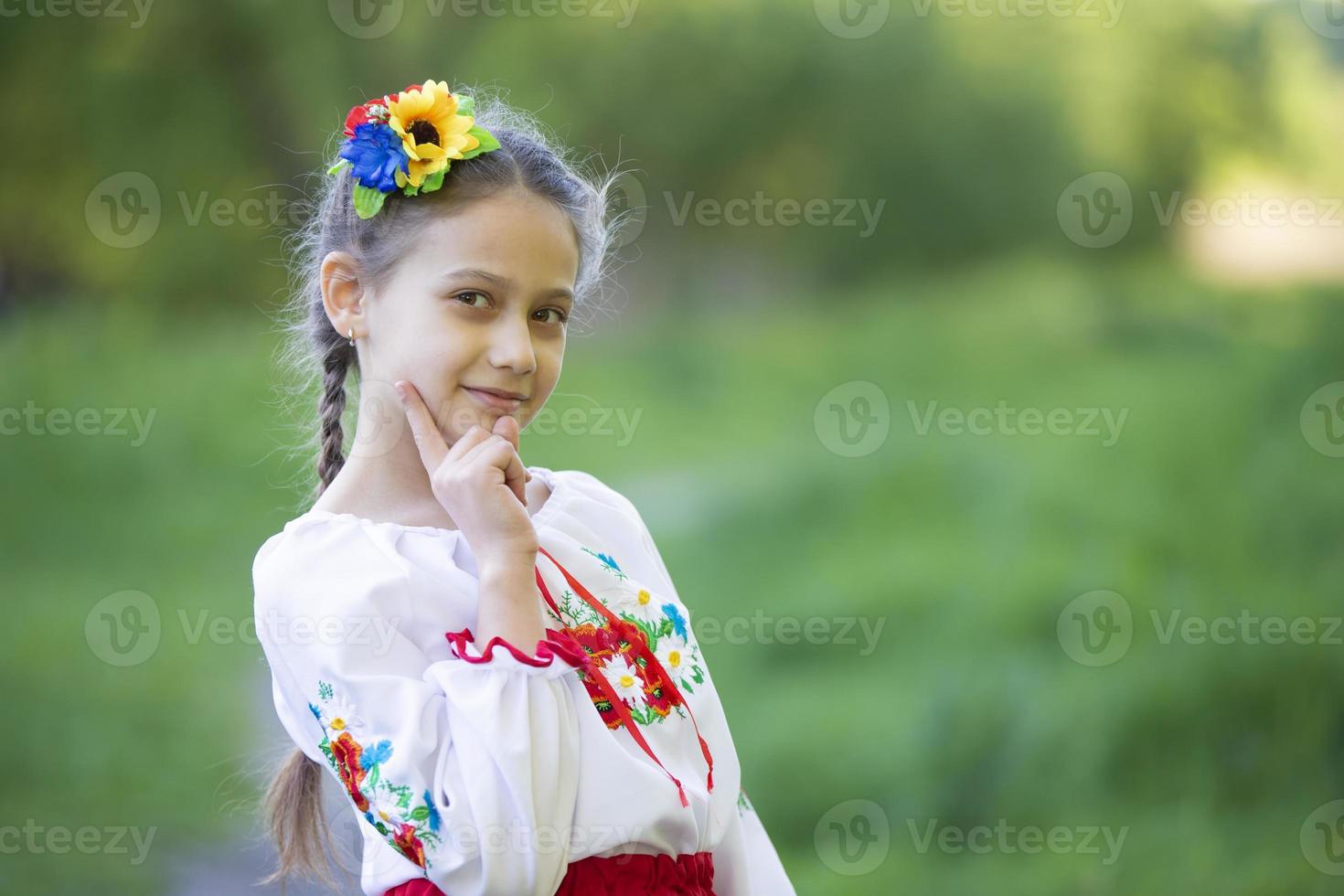 una niña ucraniana y bielorrusa con una camisa bordada en un fondo de verano. foto