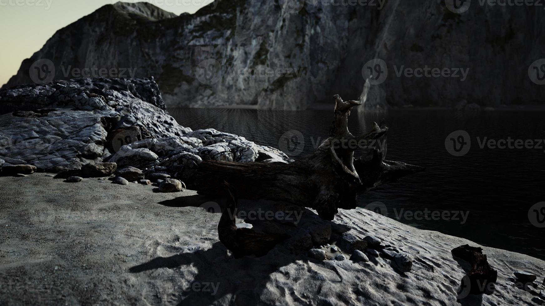 Black sand beach hidden between blurred volcanic rocks photo