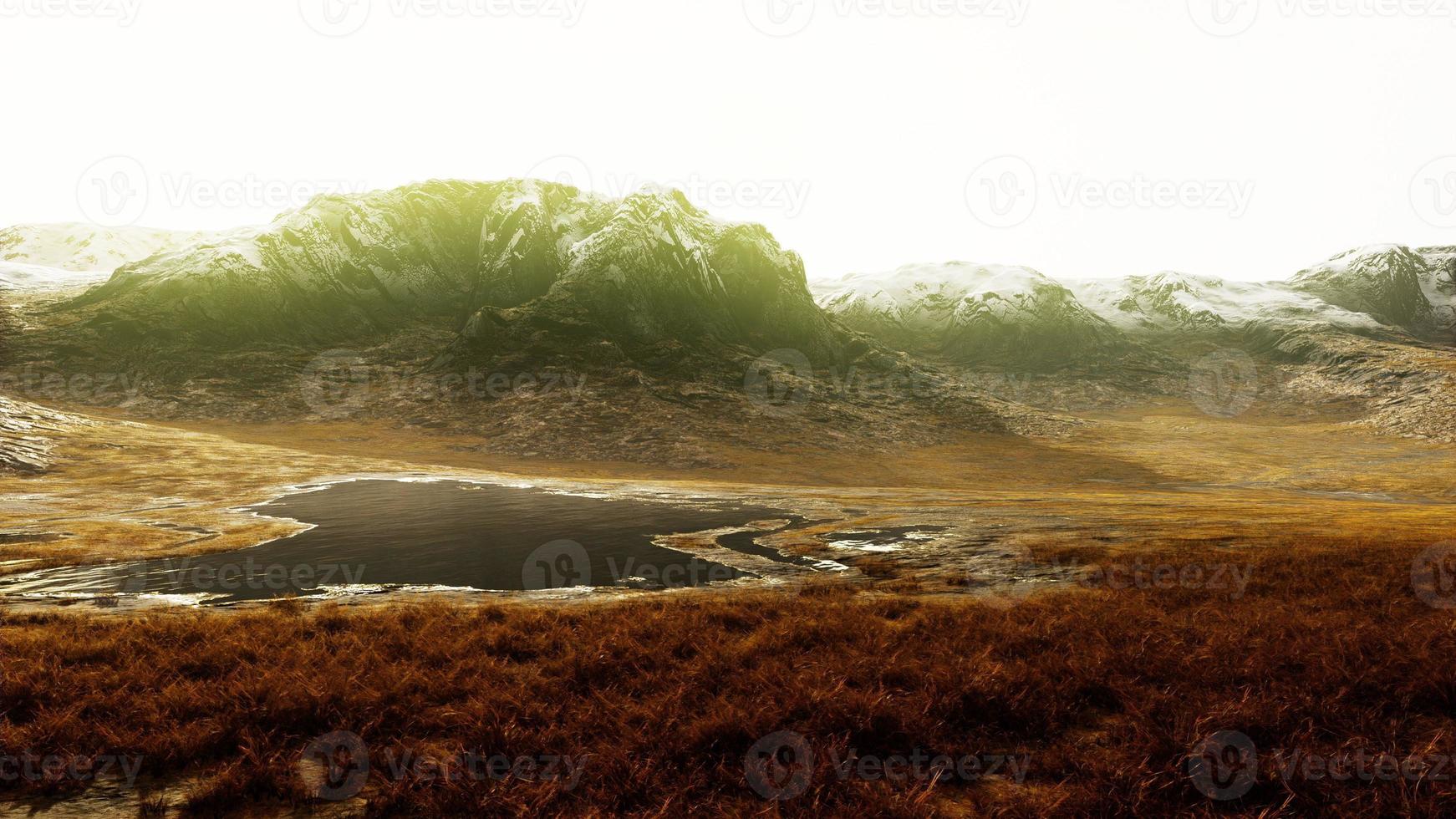 Rocky desert landscape with sparse vegetation and mountains peaks photo