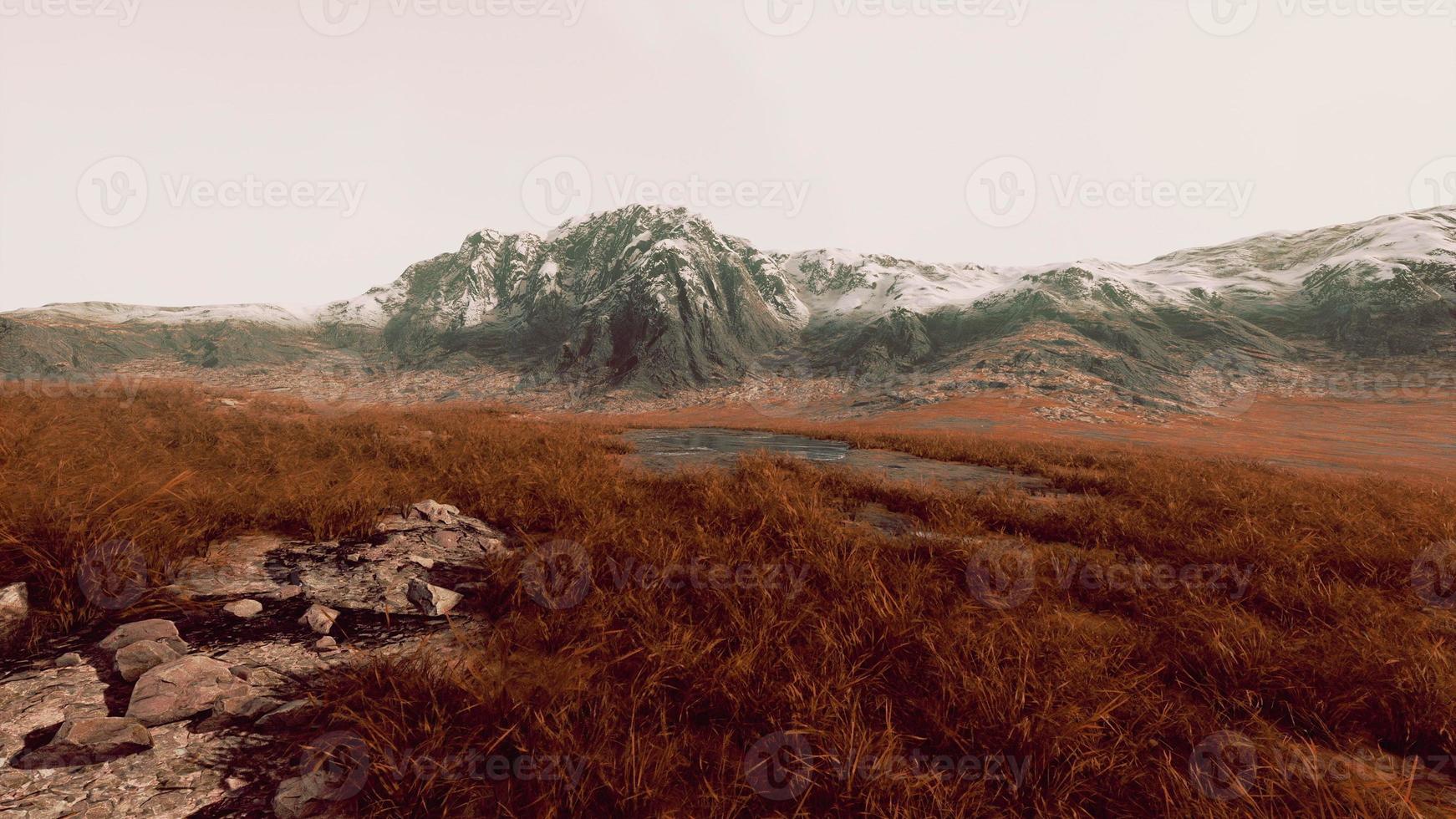 Rocky desert landscape with sparse vegetation and mountains peaks photo