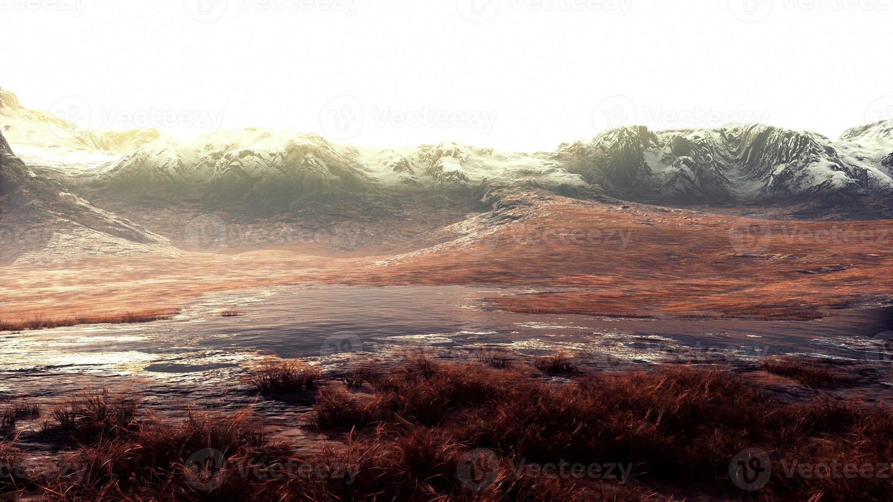 Rocky desert landscape with sparse vegetation and mountains peaks photo