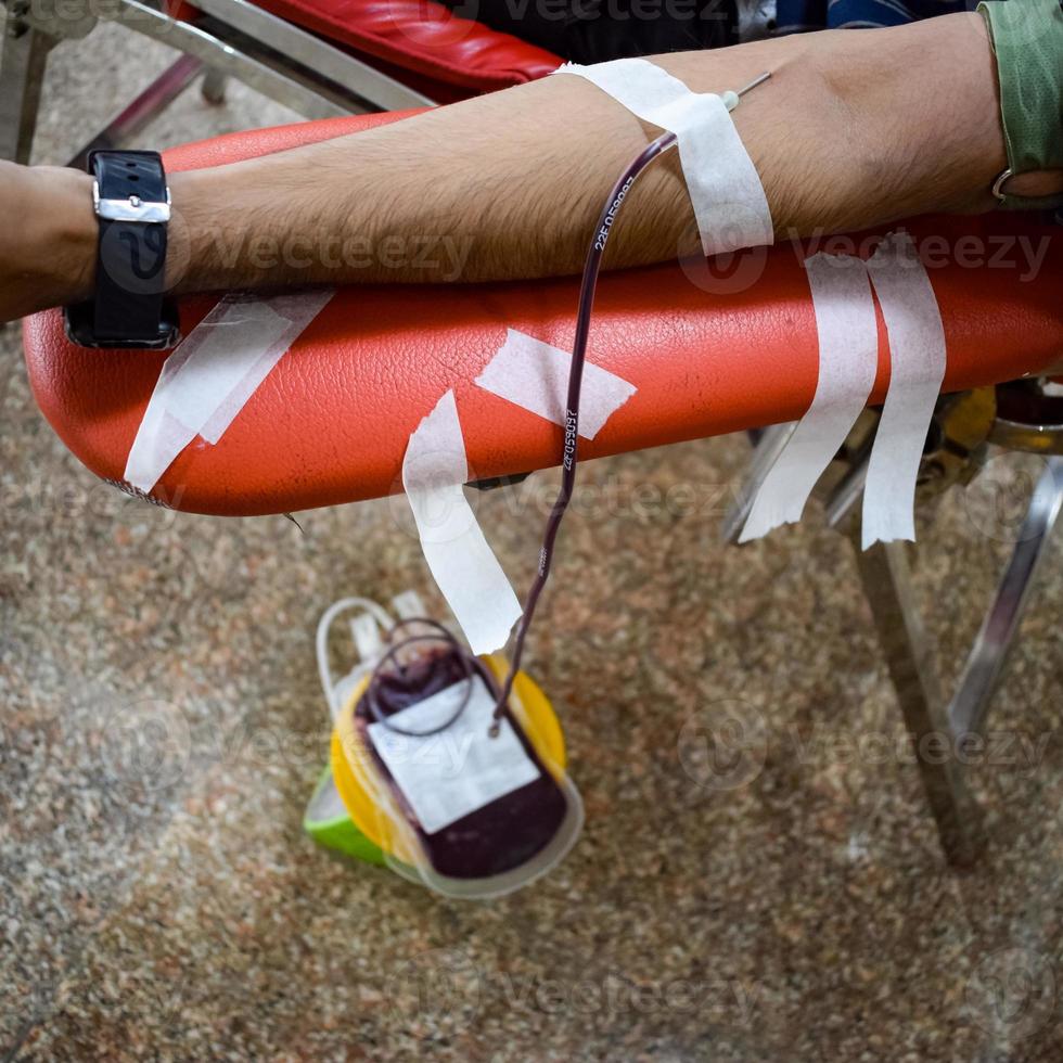 donante de sangre en el campamento de donación de sangre sostenido con una pelota hinchable en la mano en el templo balaji, vivek vihar, delhi, india, imagen para el día mundial del donante de sangre el 14 de junio de cada año, campamento de donación de sangre foto