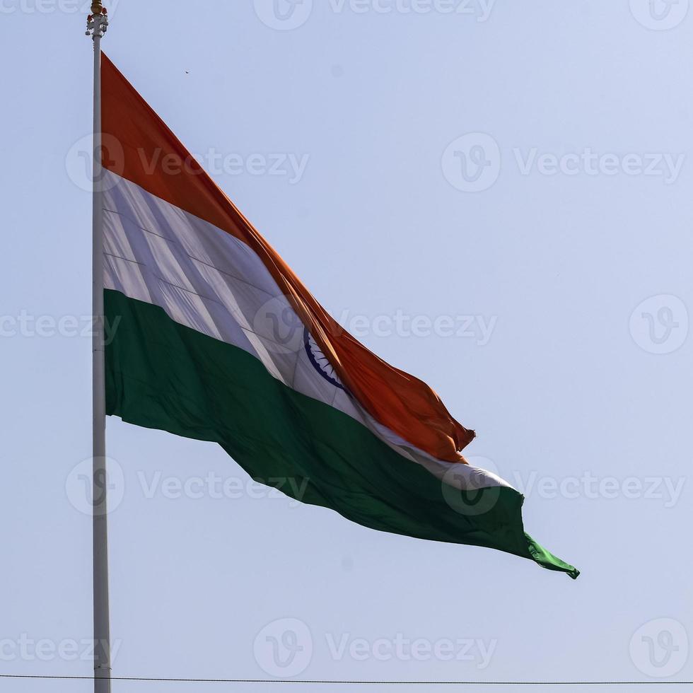 India flag flying high at Connaught Place with pride in blue sky, India flag fluttering, Indian Flag on Independence Day and Republic Day of India, tilt up shot, Waving Indian flag, Har Ghar Tiranga photo