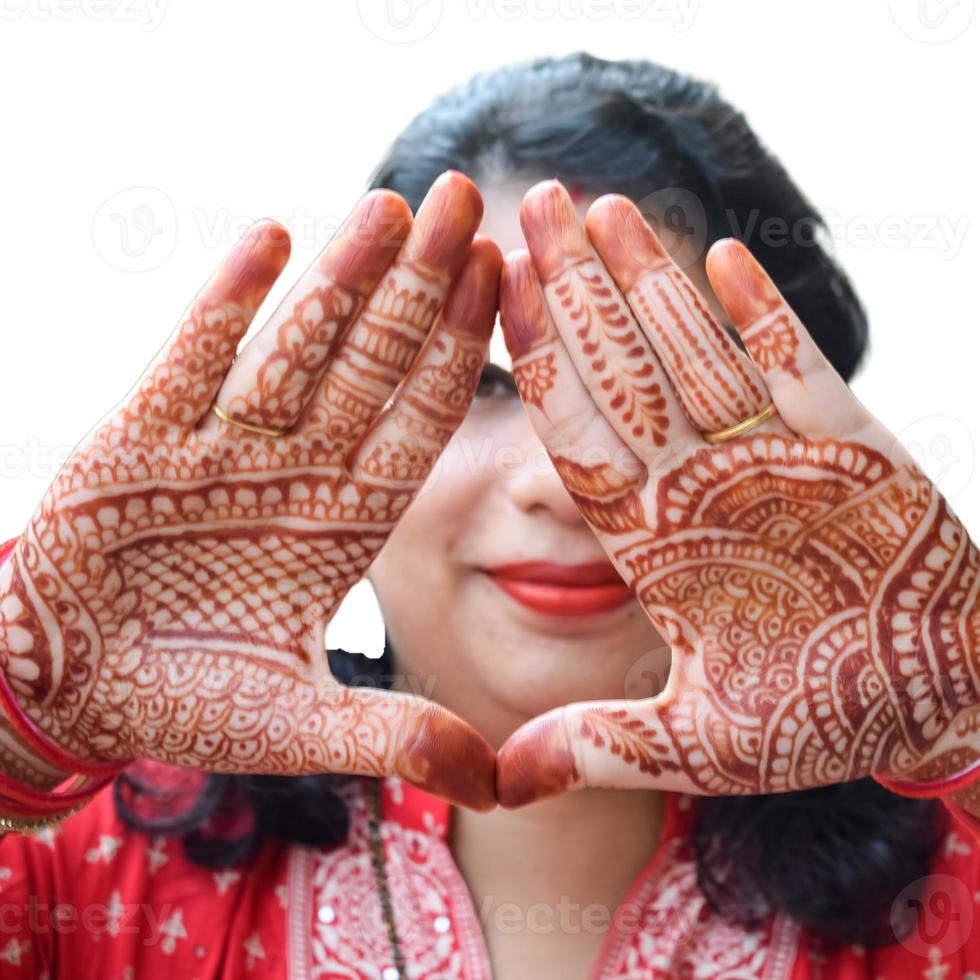 Beautiful woman dressed up as Indian tradition with henna mehndi design on her both hands to celebrate big festival of Karwa Chauth with plain white background photo