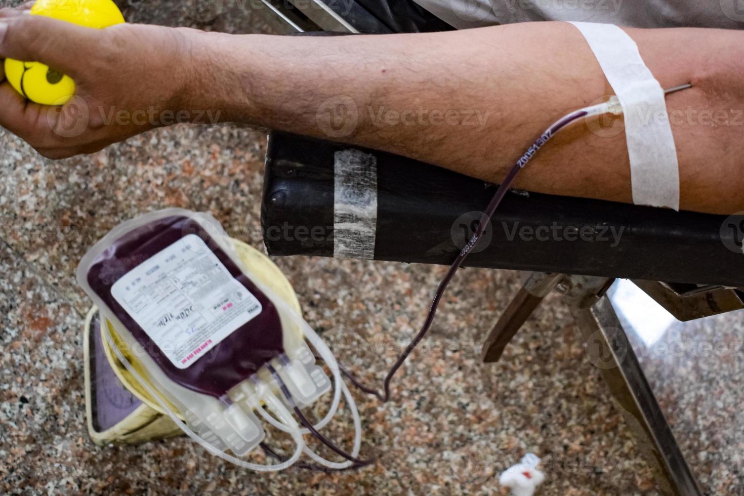 Blood donor at Blood donation camp held with a bouncy ball holding in hand at Balaji Temple, Vivek Vihar, Delhi, India, Image for World blood donor day on June 14 every year, Blood Donation Camp photo