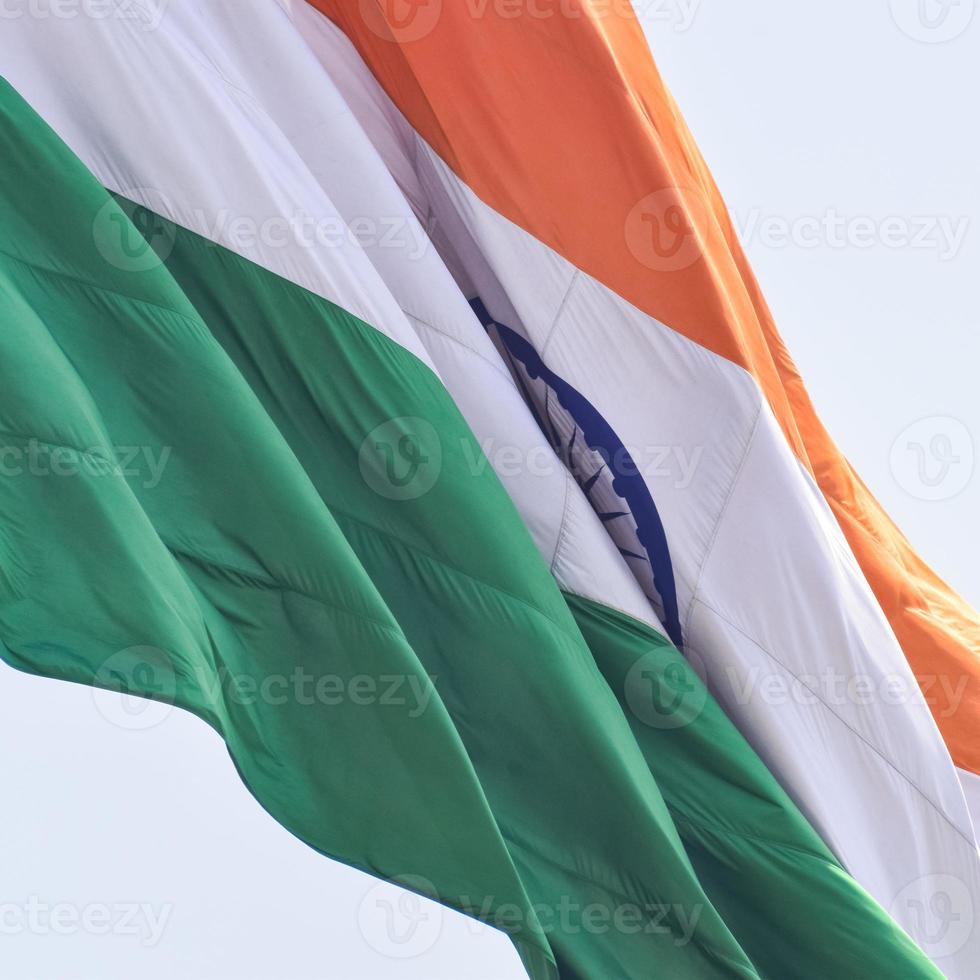 India flag flying high at Connaught Place with pride in blue sky, India flag fluttering, Indian Flag on Independence Day and Republic Day of India, tilt up shot, Waving Indian flag, Har Ghar Tiranga photo