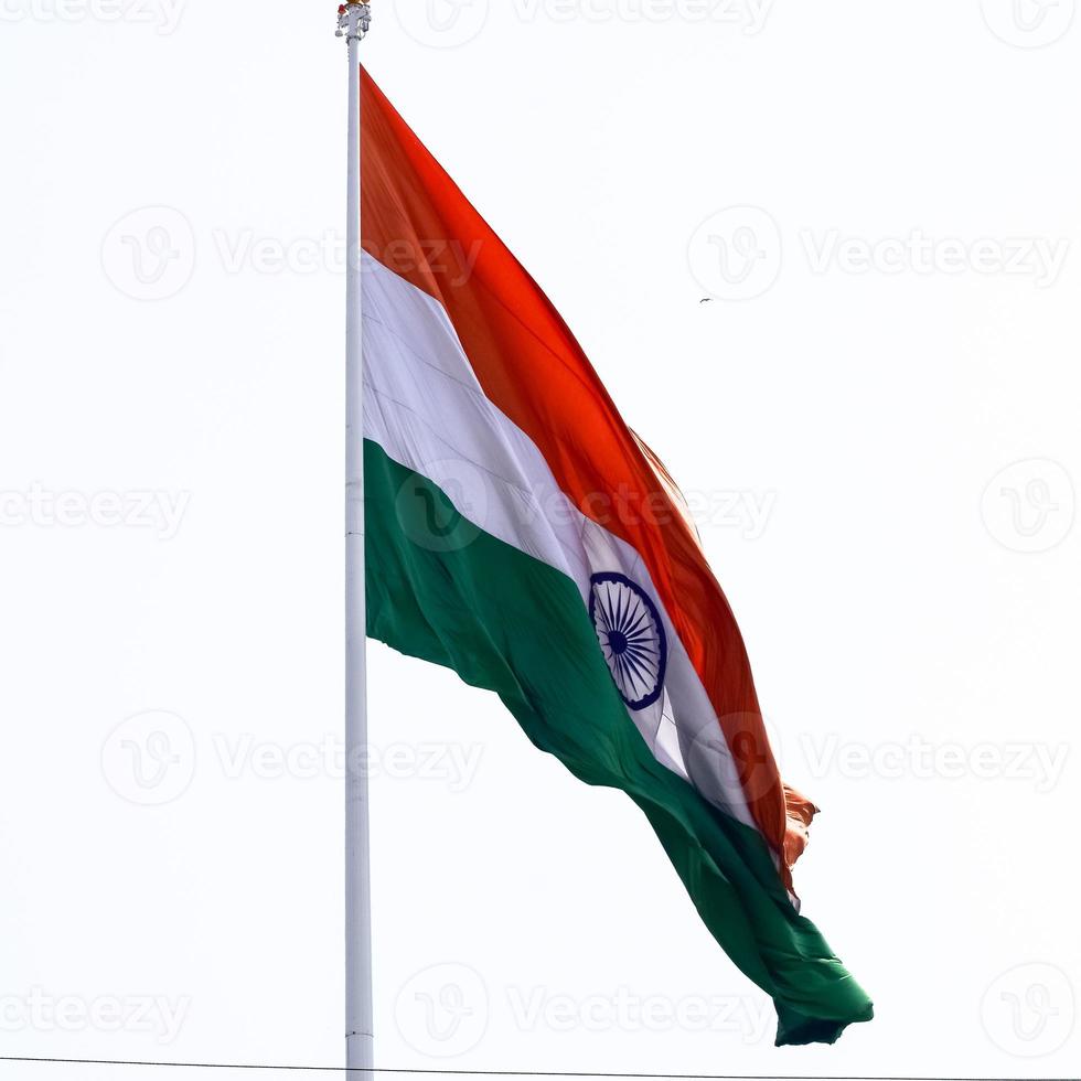 India flag flying high at Connaught Place with pride in blue sky, India flag fluttering, Indian Flag on Independence Day and Republic Day of India, tilt up shot, Waving Indian flag, Har Ghar Tiranga photo