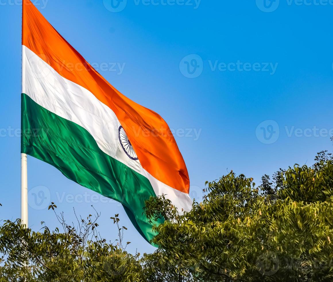 India flag flying high at Connaught Place with pride in blue sky, India flag fluttering, Indian Flag on Independence Day and Republic Day of India, tilt up shot, Waving Indian flag, Har Ghar Tiranga photo