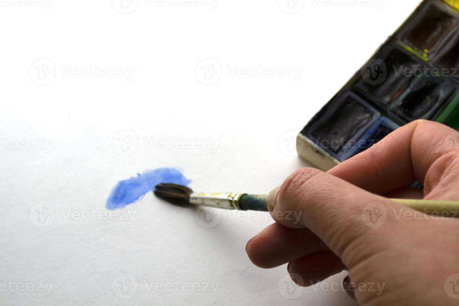 A woman paints with blue paint. photo