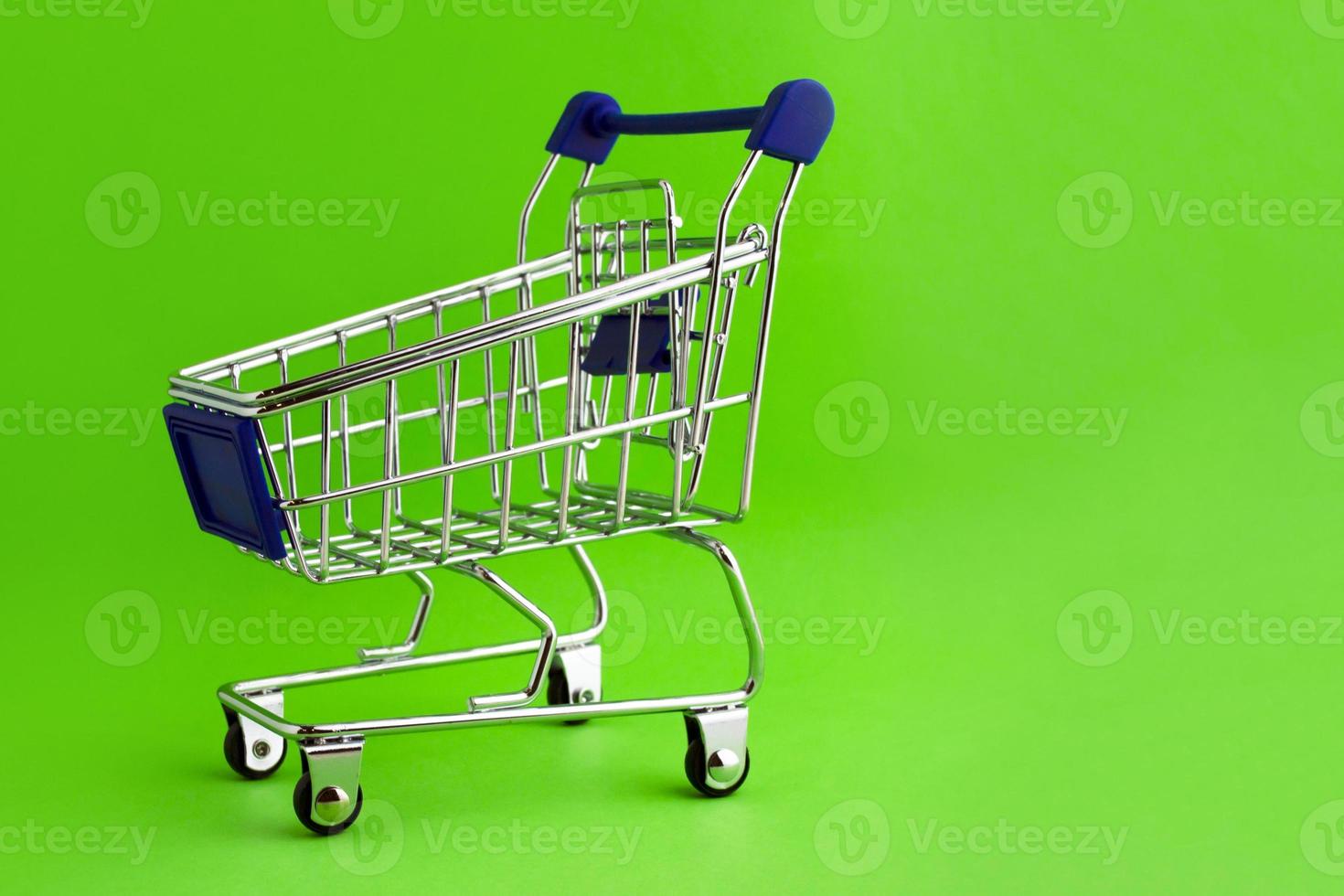 Shopping cart on a green background. photo