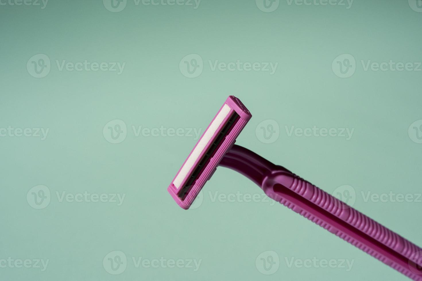 Disposable razor, a creative composition of a disposable razor on a turquoise background photo