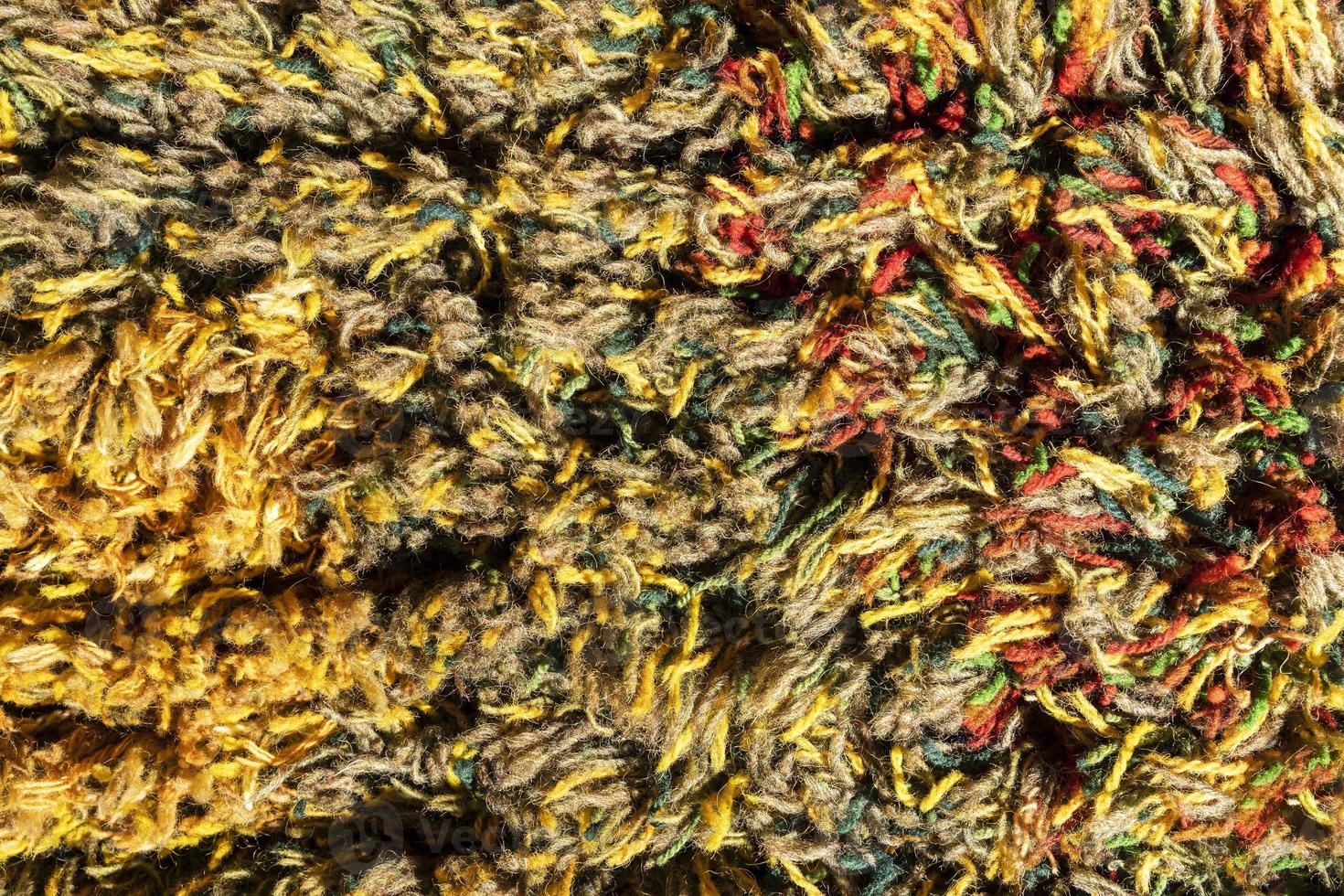 Background of a multi-colored shaggy carpet, Multi-colored rug, macro photography. Abstract texture of long-piled carpet photo