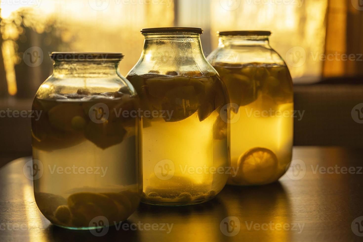 compota de manzana en frascos de vidrio en la mesa de la cocina, luz suave de la tarde foto