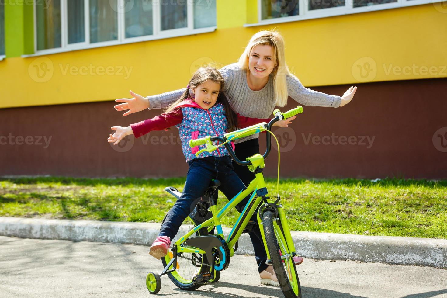 niña en bicicleta con madre foto