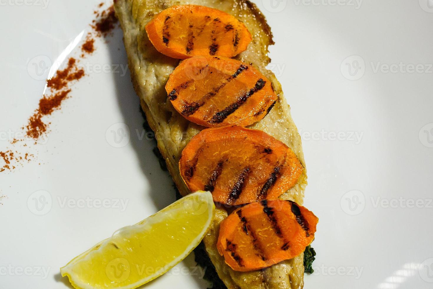 Baked mackerel fish stuffed with carrots. Top flat view. Close-up. photo
