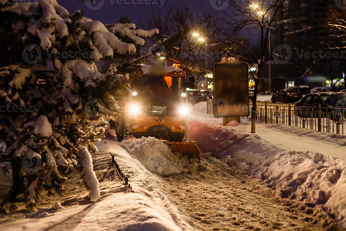 soplador de nieve limpia el camino en la ciudad foto