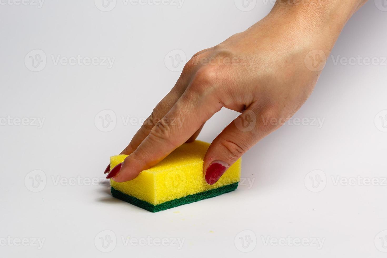 mano de mujer sosteniendo una esponja de limpieza aislada en un fondo blanco foto