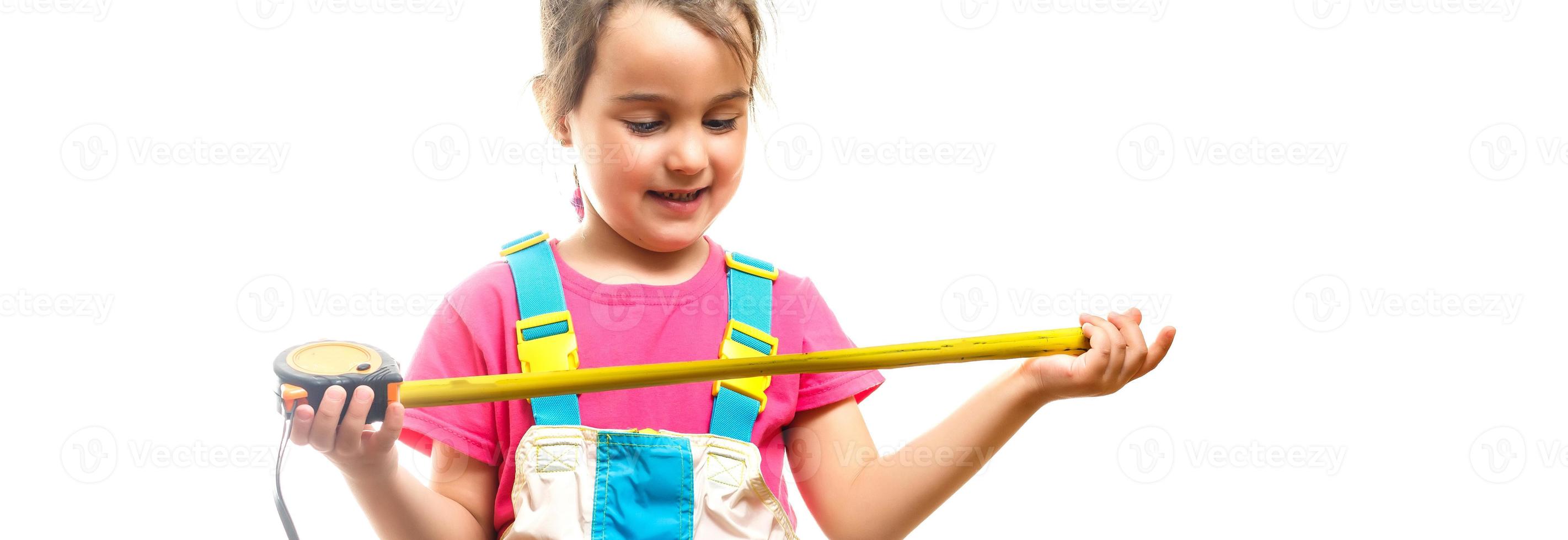 Little beautiful girl builder holding paint roller in hand photo