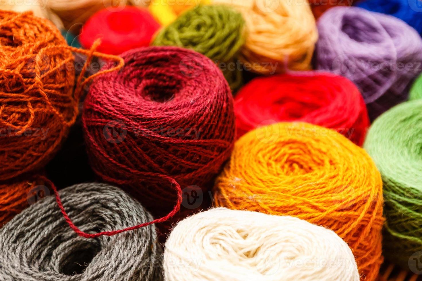 Balls of yarn scattered near the basket lots of colorful threads on old background yarns photo