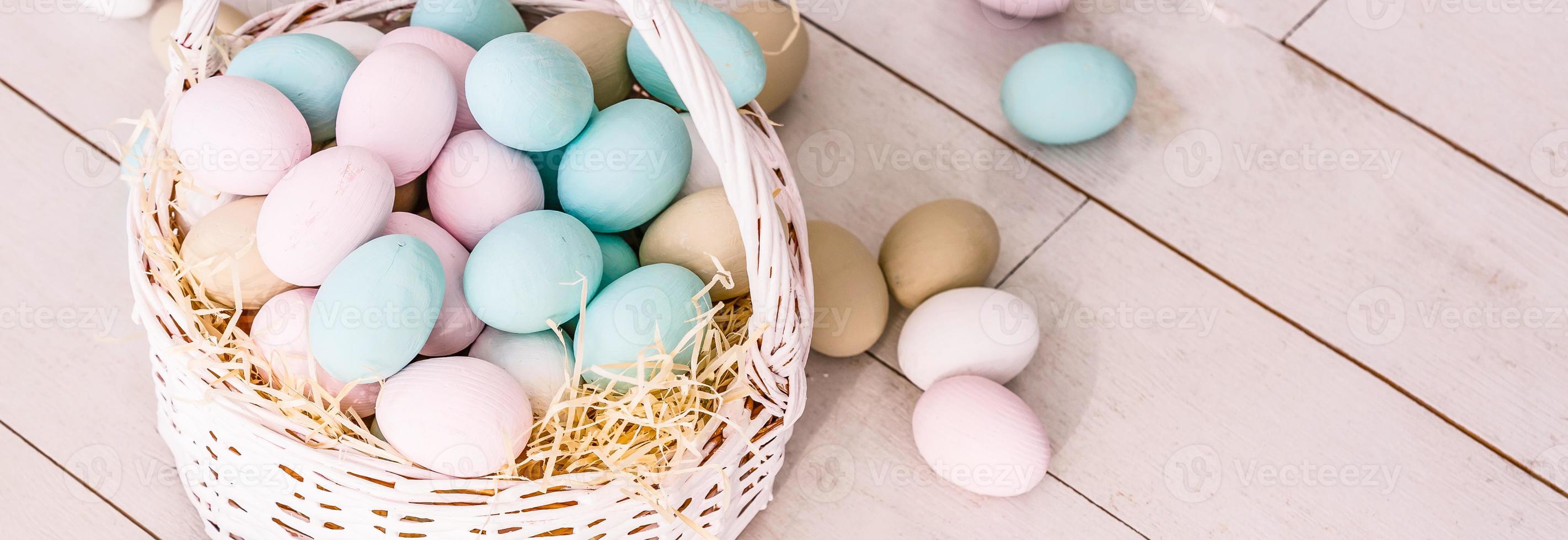 Easter eggs in nest on color wooden background photo