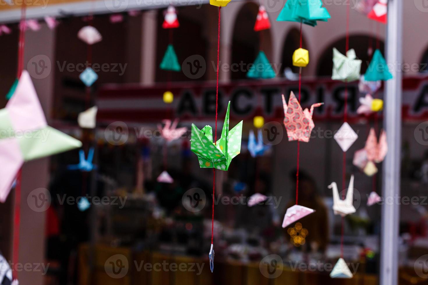 Multicolored rainbow origami paper cranes are suspended on gradient near the garland. photo