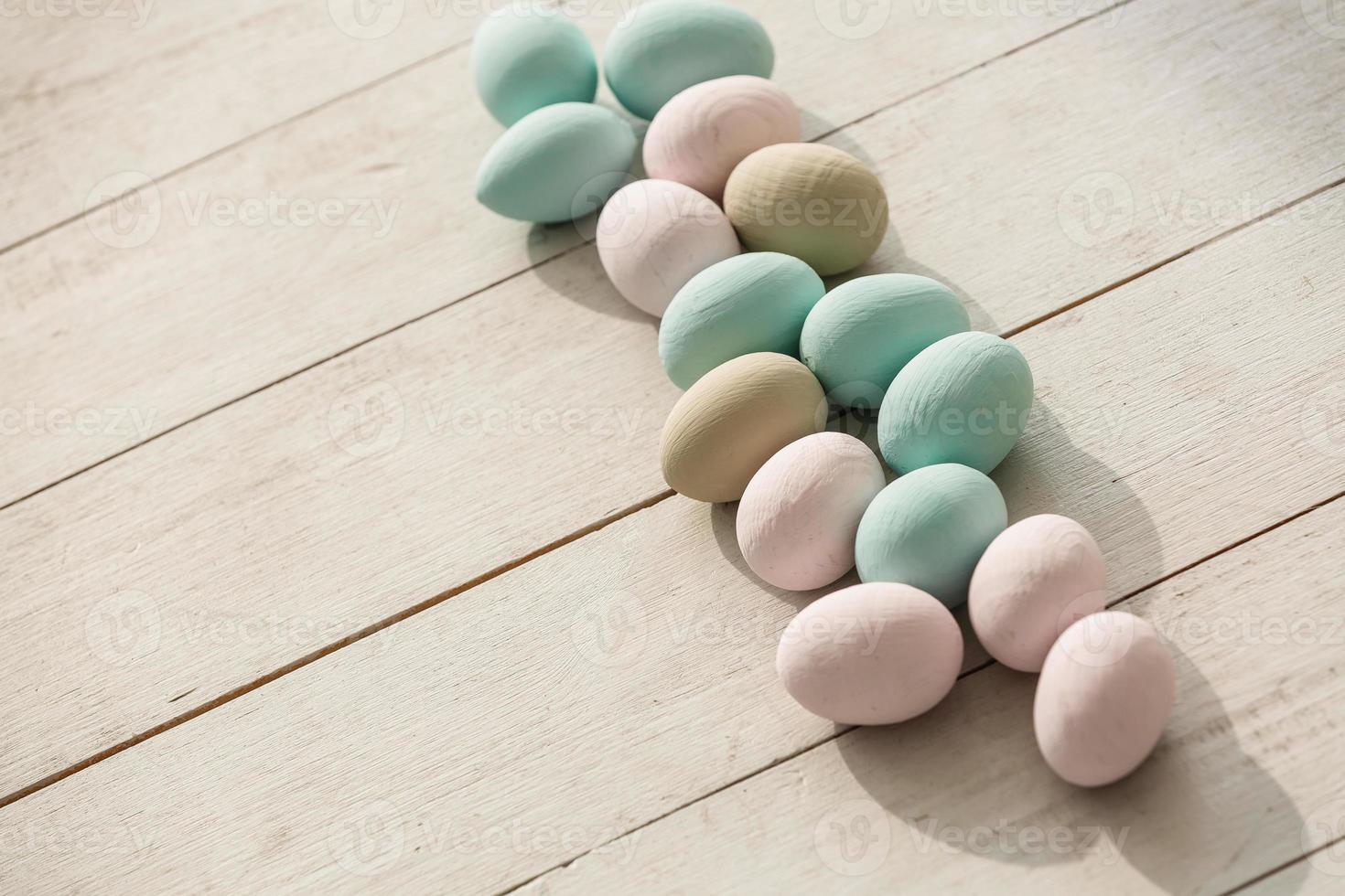 Coloeful easter eggs in nest on pastel color background with space. photo