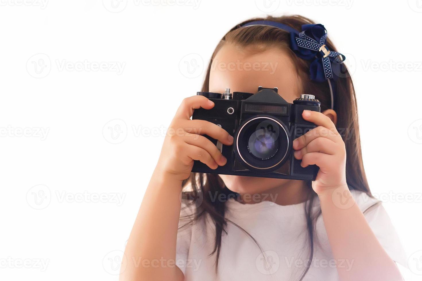 chica tomando una foto con una cámara retro profesional aislada en blanco