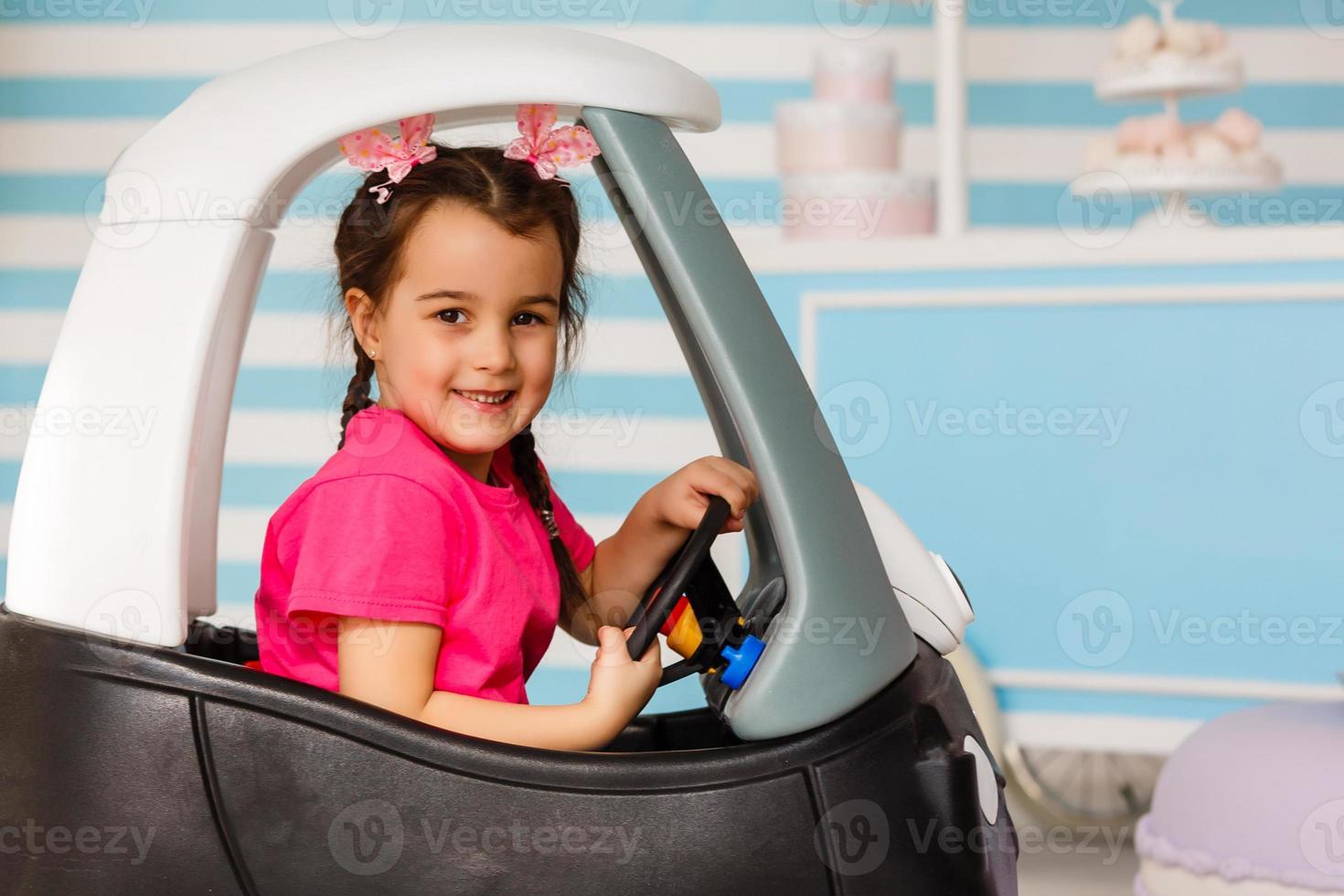 little girl in a toy car photo