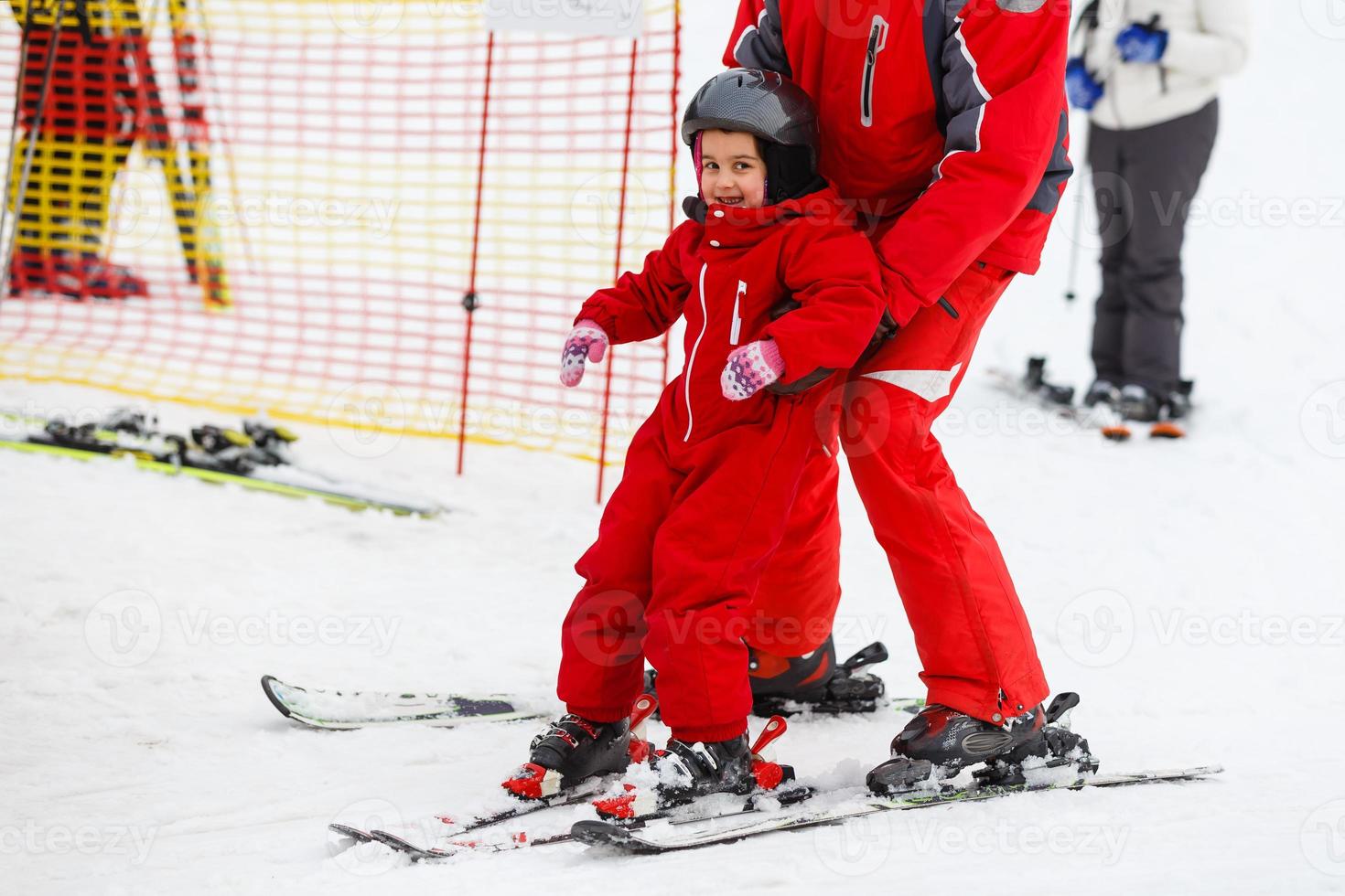 Instructor shows little girl and some exercises on skis photo